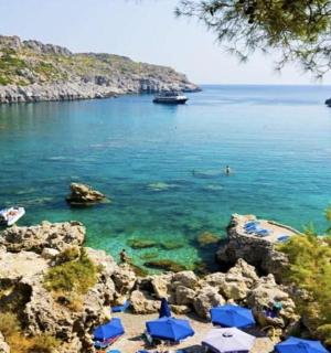 pláž s modrými slunečníky a vodou