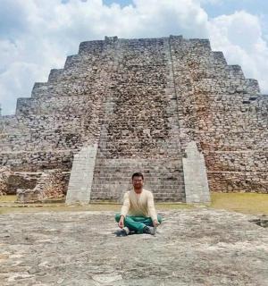 un home assegut a la part superior d'una piràmide