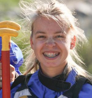 a young girl holding a baseball bat
