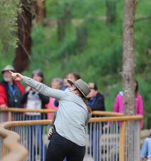 一名女子指着栅栏后面的一群人