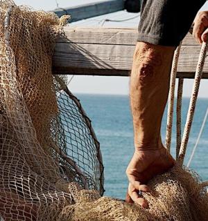 一名男子在船上拿着一张网