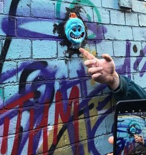 一个人拿着牙刷站在墙前