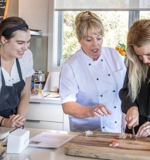 dvě ženy stojící v kuchyni a připravující jídlo