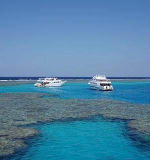 three boats floating in the water in the ocean
