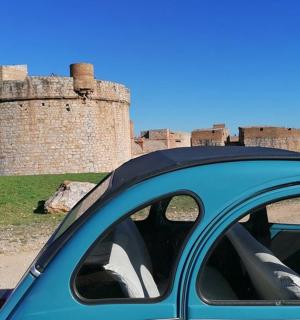 一辆蓝色汽车停在城堡前