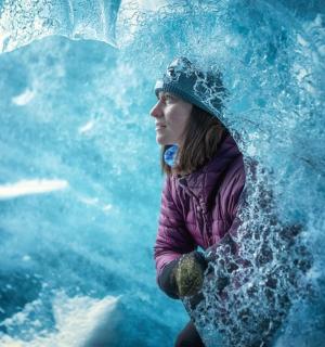 一位女士站在水族馆的海浪前
