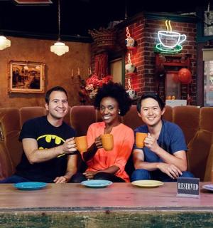 三个人坐在桌边,手里拿着杯子