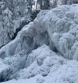 a frozen waterfall is covered in snow