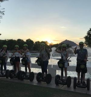 a group of people riding on segways by a pool