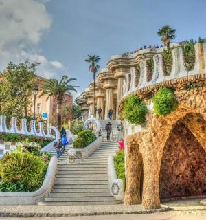 a bridge in a park with stairs and a building