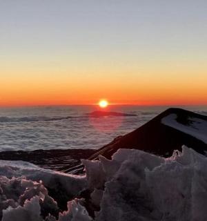 日落时站在冰山顶上的人
