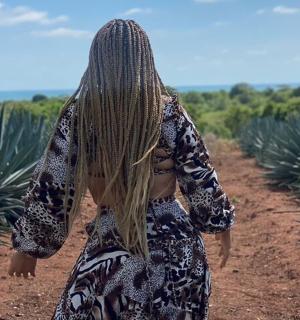 a woman is walking down a dirt road
