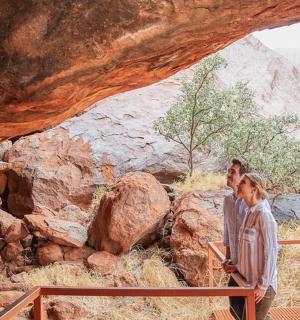 muž a žena stojící pod skalní jeskyní