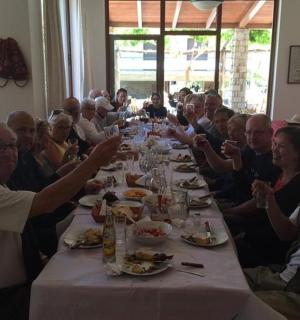 skupina lidí sedících u dlouhého stolu a jedících