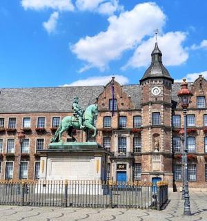 a statue in front of a building with a clock tower