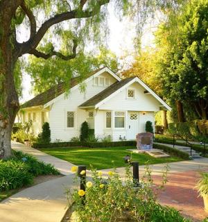 bílý dům se stromem a chodníkem