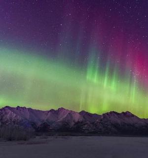 an aurora in the sky over the mountains