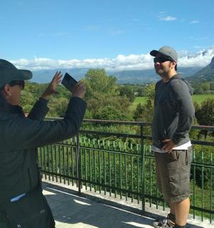 two men taking pictures of each other on a balcony