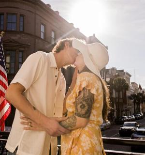 a man and a woman standing next to a flag