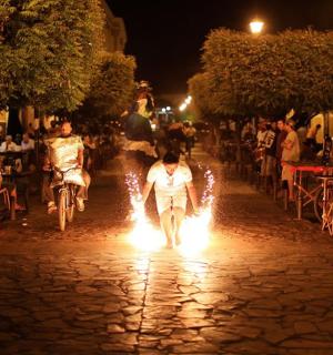 一群人骑着自行车沿着有火的街道行驶