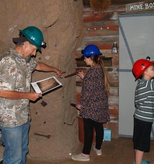 muž a žena v ochranných přilbách stojící vedle dítěte