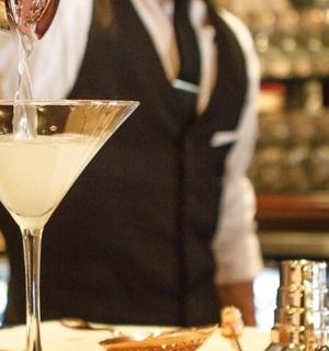 调酒师正在将饮料倒入马提尼酒杯中