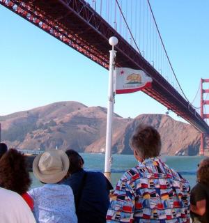 a group of people standing under the golden gate bridge