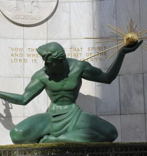 una estàtua d'un home verd sostenint una pilota