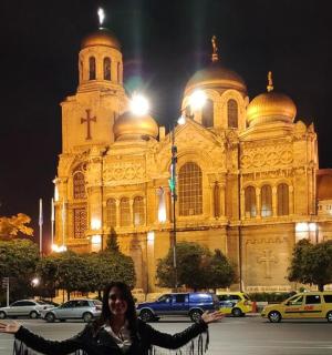 a woman standing in front of a large building