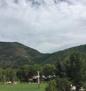 osoba pouštící draka v poli s horami