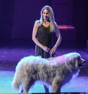 žena stojící vedle psa na pódiu