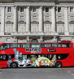 一辆红色双层巴士停在一栋建筑物前