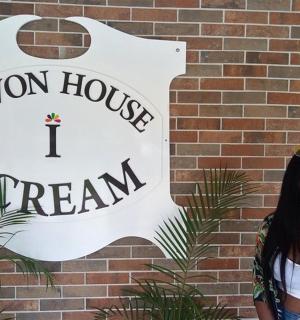 一名女子在标志牌前吃着甜筒冰淇淋