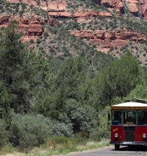 一辆有轨电车沿着山边的道路行驶