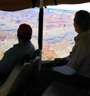 两个人坐在巴士上眺望大峡谷
