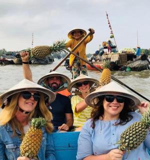 一群人在船上拿着菠萝