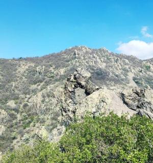 一座巨大的岩石山，山前有树木