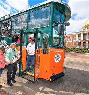 skupina lidí stojících před dvoupatrovým autobusem