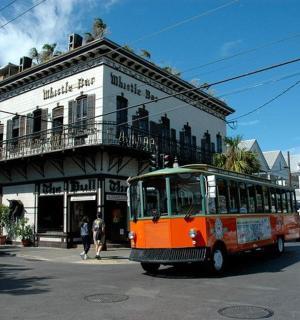 an orange bus driving down a street in front of a building
