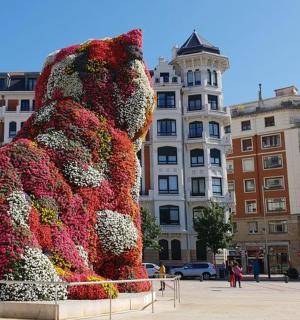 a large sculpture of a teddy bear surrounded by flowers