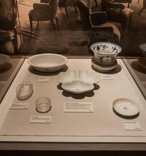 a display case in a museum with bowls and plates