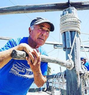 muž v modré košili stojící na lodi