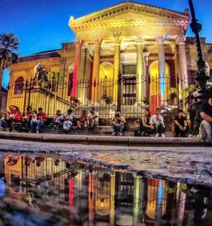 一群人坐在一栋建筑物前