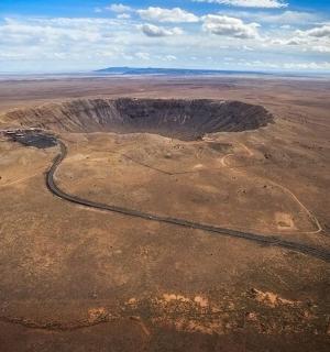an aerial view of a desert with a winding road