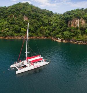 a white boat in the water near a mountain