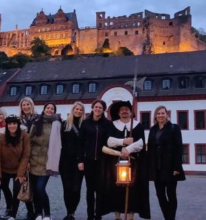 a group of women standing in front of a castle