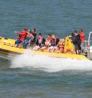 a group of people on a yellow boat in the water