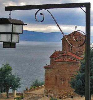 a street light next to a church next to the water
