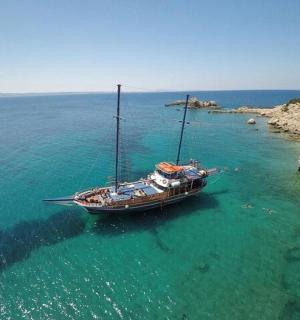 a boat sitting in the water next to a cliff