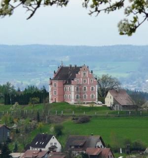 a large house on top of a hill with houses